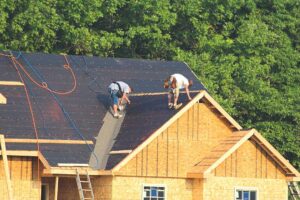 A homeowner compares a low flat roof and a pitched shingle roof on neighboring residential buildings after snowfall.
